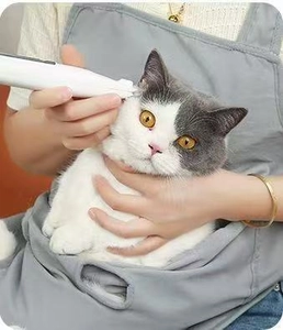 Detail of the cat grooming apron and electric trimmer used for pet hair care and trimming