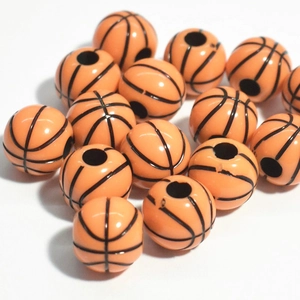 Macro view of orange acrylic basketball beads with classic black lines for jewelry making