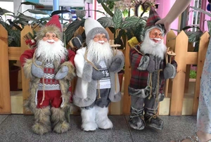 Detailed close-up of three Santa Claus dolls in red, white and grey plaid costumes