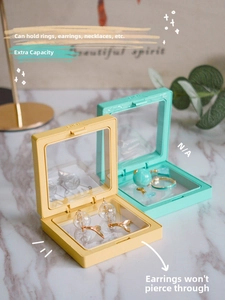Macro detail of yellow and green PE film suspension jewelry boxes on marble background