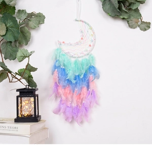 Close-up of moon dream catcher hanging ornament with colorful feathers and bead detail