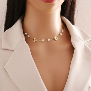 Gold stainless steel double layer necklace with white pearls and clover charms on model