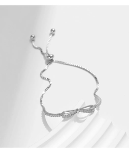 Macro view of adjustable S925 silver bracelet with sparkling bow and pavé zircon stones