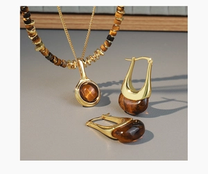 Detail view of tiger eye stone necklace and earrings set with gold-plated finish