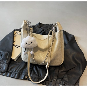 Detail of cream woven Hobo bag with silver chain and white cloud plush charm