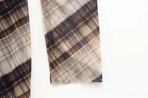 Close-up of semi-transparent mesh fabric with vintage brown and khaki plaid pattern detail