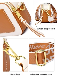 Detailed close-up of brown and cream crossbody bag with golden hardware and wide strap