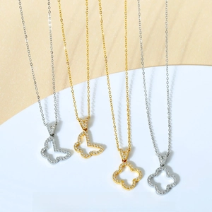 Close-up of titanium steel necklaces with gold and silver clover and butterfly pendants