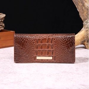 Macro shot of brown crocodile embossed leather texture on a long luxury wallet