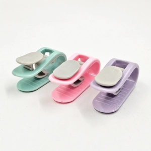 Macro detail of needle-free quilt cover clips in mint green, pink, and purple colors