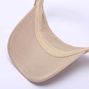 Détail d'une visière beige avec coutures renforcées et texture de bande anti-sueur