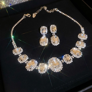 Silver jewelry set with necklace and stud earrings featuring oval diamonds in a display box
