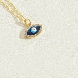 Detailed macro shot of a golden evil eye pendant with blue enamel and zircon inlay