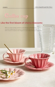 Detail of pink petal-shaped ceramic coffee cup with gold spoon and matching saucer