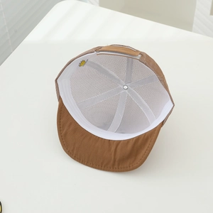 Detail view of breathable brown mesh baby hat with adjustable velcro strap and cotton brim