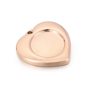Close-up of rose gold heart pendant with round recessed center and metallic texture