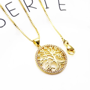 Macro detail of a gold tree of life pendant with micro-inlaid cubic zirconia on box chain