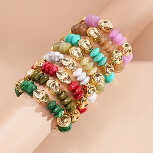 Macro detail of bohemian beaded bracelet set with irregular gold metal and colorful stone beads