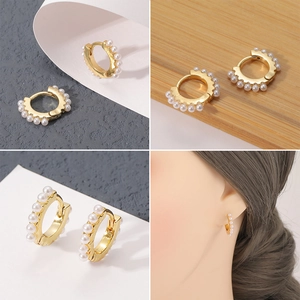 Detalle de pendientes de aro bañados en oro 18K con microperlas y estilo de modelo