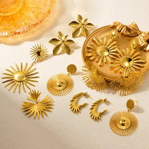Luxurious 18k gold plated sun flower drop earrings and studs on a textured background