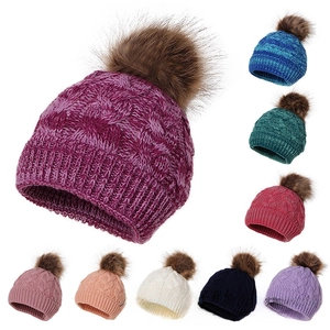 Detailed grid of cable knit winter beanies with large faux fur pom-poms in nine vibrant colors