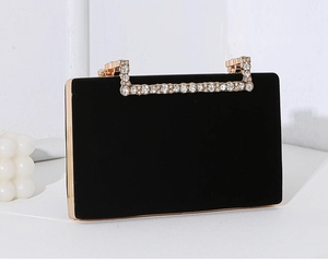 Detailansicht einer luxuriösen schwarzen Samt-Clutch mit strassbesetztem Goldgriff