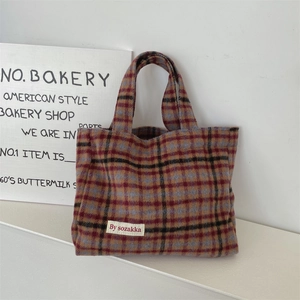 Close-up of the textured wool fabric and red-blue plaid pattern on the vintage tote bag