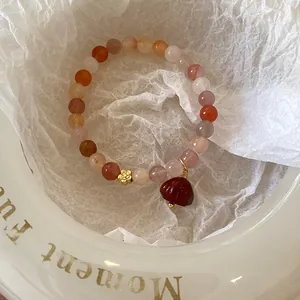 Détail d'un bracelet en perles d'agate multicolores avec breloque fleurie élégante
