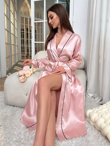Dettaglio dell'accappatoio in seta rosa con bordo nero e cintura in vita
