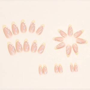Almond-shaped French press-on nails in pale yellow with white floral and leaf patterns