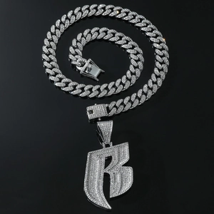 Close-up of hip hop silver Cuban link chain and sparkling iced-out letter B pendant
