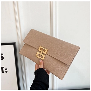 Détail d'une pochette beige à motif crocodile avec une boucle en métal doré rectangulaire