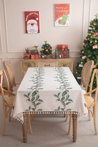 Detail of Christmas tablecloth with holly berry print, fringe edges, and cotton-linen texture