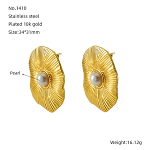 Macro detail of 18K gold plated stainless steel pearl earrings with radial texture