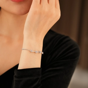 Close-up of elegant silver bracelet with pink purple round cut zircons on a wrist