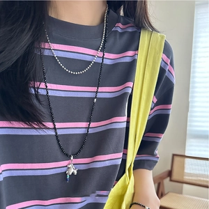 Double-layered beaded necklace featuring a silver elephant pendant on striped apparel