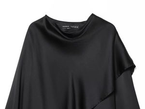 Detail of black satin fabric blouse showing smooth silk texture and sizing label info