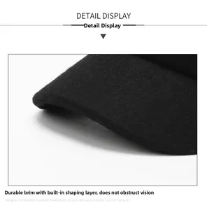 Close-up of a black wool flat cap showing a reinforced brim with built-in styling layer