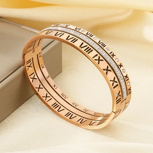 Macro shot of rose gold titanium bangles with Roman numeral cutouts and paved crystals