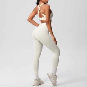 Detalle del sujetador deportivo con espalda cruzada y leggings de yoga en color crema