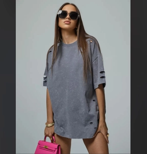 Detailed view of the distressed vintage washed fabric and ripped holes on grey t-shirt