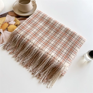 Flat lay of plaid cashmere scarf with soft tassels beside coffee and a fashion magazine