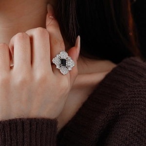 Close-up of vintage silver ring with black rectangular gemstone and floral details