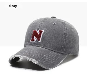 Detail of distressed brim and red N letter embroidery on vintage gray baseball cap