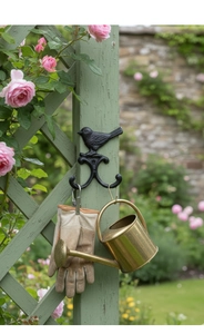 Schwarzer Vogel-Doppelhaken aus Eisen im Freien mit Gartenhandschuhen und Gießkanne