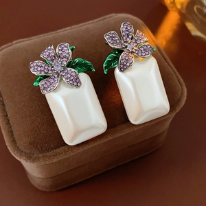 Détail de boucles d'oreilles vintage avec strass violets et perles sur boîte en velours