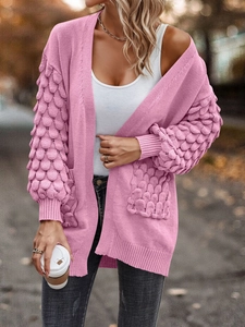 Detailed view of pink v-neck cardigan featuring textured scale-knit sleeves and pockets