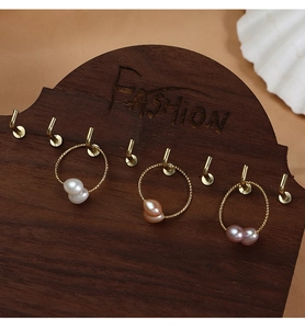 Three natural pearls in white, orange and purple on golden textured hoop earrings