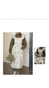 Detail of vintage floral cotton apron featuring elegant ruffles and functional side pockets