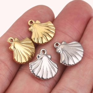 Pendentifs coquillages en or et argent pour bijoux DIY présentés sur une main